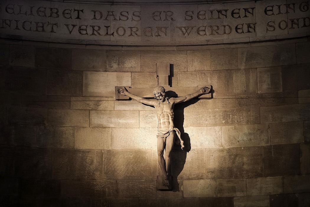 An image of a crucifix on a stone wall.